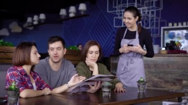 Arkadaş kafe, üç, iki güzel kızları ve çekici bir genç adam. Genç insanlar bir sipariş için Smartphone-e doğru yazıyor garson, menüsünde yapar.