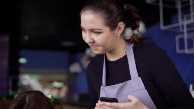 Arkadaş kafe, üç, iki güzel kızları ve çekici bir genç adam. Genç insanlar bir sipariş için Smartphone-e doğru yazıyor garson, menüsünde yapar.