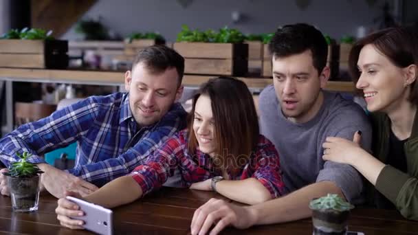 Des mecs et des filles attirants au café, font du selfie au téléphone. Une entreprise d'amis est photographiée ensemble pour les réseaux sociaux. Les étudiants des designers ont un jour de congé — Video