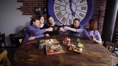 Bir masada atıştırmalıklar ile modern bir restoranda şirin gençlerin bir grup. Erkekler ve kızlar şarap ve bağırarak şerefe kadeh ile pişmiş olan. Arkadaşları başarılı sözleşme veya doğum günü kutlaması.