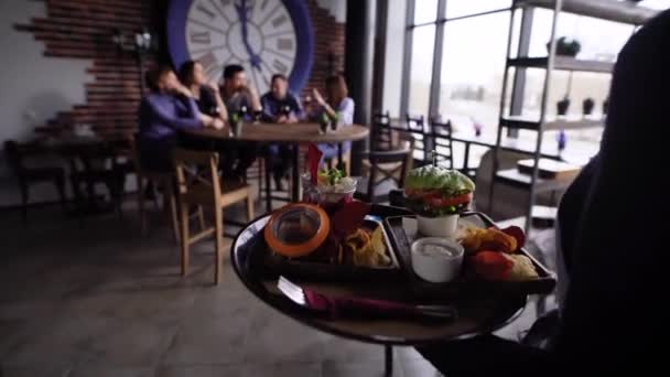 Ober brengt voedsel voor gasten — Stockvideo