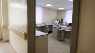 Bir elbise giymiş birkaç kadın laboratuar teknisyenleri bir anamnez hastaların özel bir klinikte kaydetmek için hasta analiz çalışmaları yapıyorlar