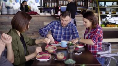 Restoranda bir kaç arkadaş kısa saç öğle yemeği ile domates ve peynir, ızgara, şirket ile sandviç yeme kapuçino ve sütlü kahve sever