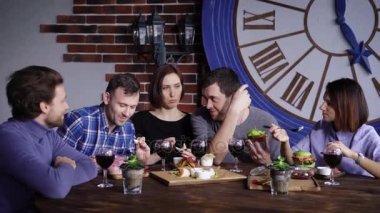 Bir grup yetişkin arkadaş birbirlerine bir restoranda akşam yemeği yemek getirdiler gıda hakkında konuşurken görmedim arkadaşlar kırmızı şarap için lezzetli aperatifler gibi.