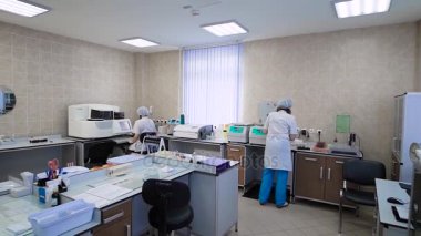 Laboratuvar ile çalışan insanlar. Farklı ekipman ve çalışan diğer uzmanlar ile klinik laboratuvar ters atış.