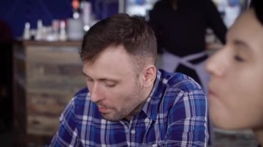 Restoranda arkadaşları ile oturma ve mavi kupa kahve içme genç adam. Kafeteryada kahvaltı ve sabah çay içiyor öğrenci.