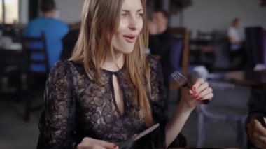 Bir çift, bir erkek ve bir kadın modern bir restoranda öğle veya akşam yemeği var. Bir erkek ve bir kadın yemek keyfini ve sosyal bir görüşme. Randevun olduğu için aşk, gülüyorlar.