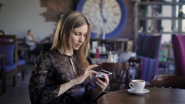 Hermosa mujer de negocios pide boletos para un avión en línea, sentado en un café. La chica utiliza la banca por Internet y la tarjeta de crédito, para transacciones y compras en la red. Comercio electrónico conveniente — Vídeos de Stock