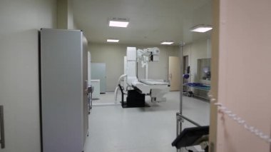 Görüntü boş temiz steril x-ray kabine modern tıbbi cihazlar, yeşil kanepe ve odanın merkezinde büyük radiographical cihaz.