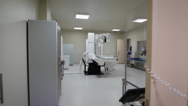 Imagem do armário estéril vazio do raio-x com equipamento médico moderno, sofá verde e dispositivo radiográfico grande no centro da sala . — Vídeo de Stock