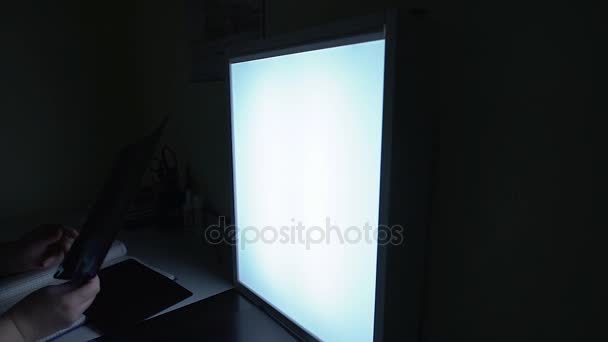 Close up of a hand of a doctor in medical clinic setting x-ray shot on the display to recognize injury of patient. Light board with the roengen scan of a head is fixed on the table. — Stock Video