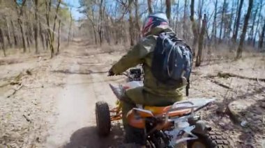 Genç bir gencin kafasına koruyucu bir kask giyen bir adam bir ülke yolda bir dört tekerlekli dörtlü Atv sürme