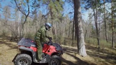 Yarış ormanın içinde. Adam yavaş yavaş sonbahar iskele Atv sürmek. Ormanda bir Atv off-road üzerinde eğitmek kolay sürüş