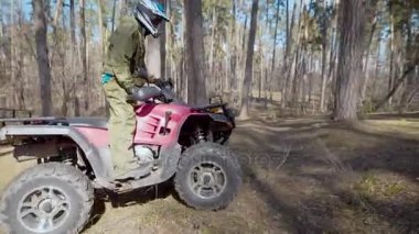 Yarış ormanın içinde. Atv adam. Özel bir form ve bir kask adam sessizce Atv orman yollarda sürmek..