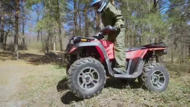 Hösten skogen. Mannen i en speciell form på Atv. Racer rider på trä racing quad cykel. — Stockvideo