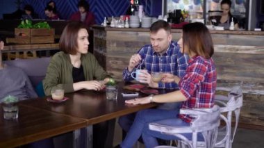 Arkadaş grubu bardak kahve masada oturan