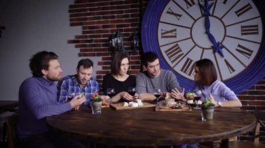 Bir grup insan birlikte yemeğe gülüyor