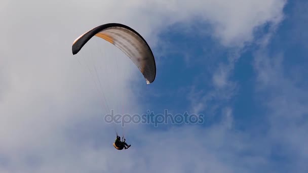 El parapente en el cielo, vuela en las corrientes de aire. La sensación de libertad se cierne en las nubes. Equipamiento moderno — Vídeo de stock