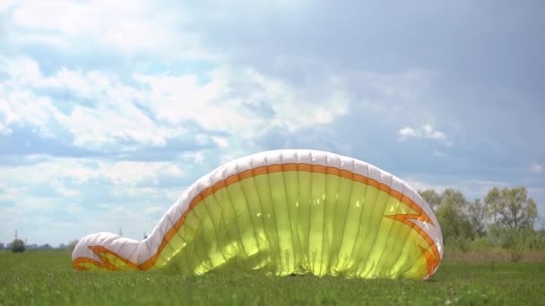 Parapente masculin, vérifie l'équipement au sol. La sécurité est importante pour voler dans le ciel . — Video