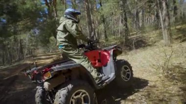Arkadan Görünüm onun off-road aracı işletim ve yan yana kayma ormanın içinden hareket Atv binici. Aşırı traveller ağaçlarda quad bisiklet sürme ve öncesinde hareket.