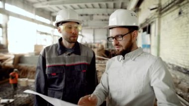 İşadamı işçisi inşaatı tamamlanması gecikme nedenleri bulur modernize binanın, adamlar