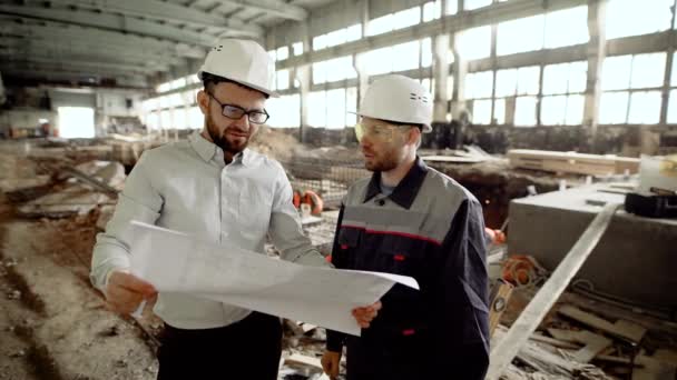 O arquiteto-chefe explica o capataz da sutileza do canteiro de obras, que será modernizado para um aquapark da cidade — Vídeo de Stock