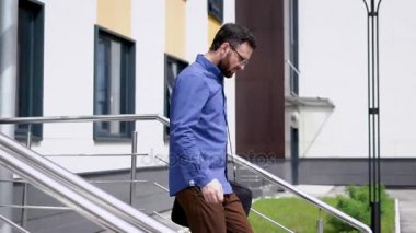 Bir çekici ofis çalışanı ofis binası, onun omuz çantası belgelerle bir adam üzerinden merdivenlerden iner