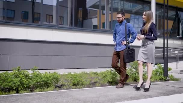Colleghi sul lavoro passeggiano vicino all'edificio del modulo durante la pausa pranzo, si dirigono verso l'ufficio per continuare il loro lavoro. — Video Stock