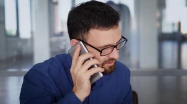 Bir yatırımcı bir cep telefonu ile müzakere yetişkin bir adam ve genç bir kadın, Bayan bir not defterinde alınan bilgileri kaydeder
