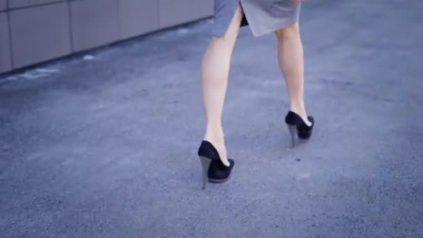 A young secretary with a good figure returns to work in the companys business after a lunch break, which took place in a nearby building — Stock Video