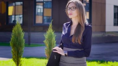 Seksi iş kadını o buna işleri firması yanındaki cadde boyunca yüksek topuklar üzerinde ellerini önemli belgeleri ile doludur