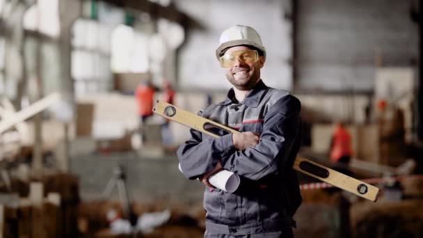 Форман на стройке. Мужчина в специальной униформе и в шлеме на голове на стройке промышленного объекта . — стоковое видео