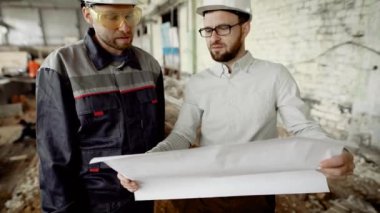 Mimar ve işçi bitkinin inşaat sahasında. Baş mimarı aracılığıyla çizimine benziyor ve üzerinde daha fazla çalışma karar verir.