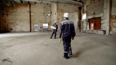 Bina. Builder hızla inşaat alanında ana ustası taşır. Erkek el sıkışın ve çizim inşaat hataları hesabını iletişim.
