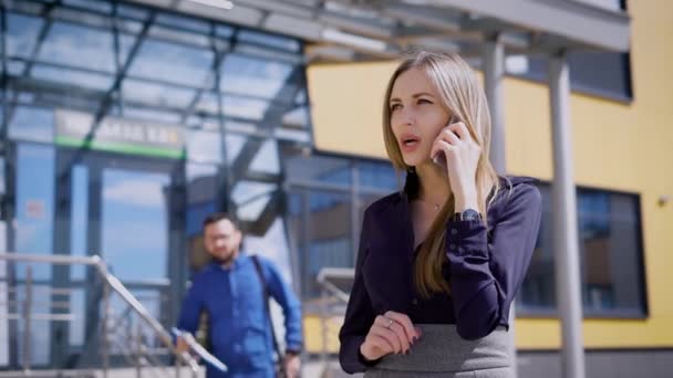 Podnikatel ve dvoře budovy úřadu. Žena hovoří do telefonu. Obchodní konverzace. — Stock video