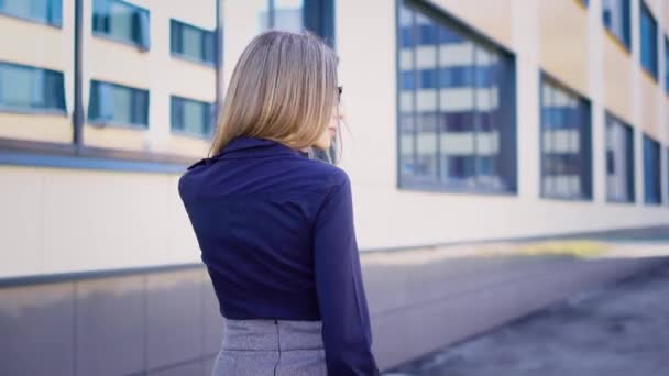 Strada. Edifici di business center. Un giovane lavoratore si affretta a lavorare. La donna è vestita con un baccalà . — Video Stock