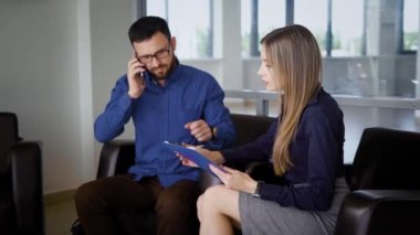 Ofis binası içinde. Resepsiyon. Evet iş adamı. Adam aynı anda talimatları sekreteriyle veriyor..