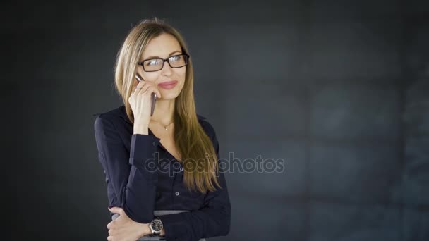 Mulher de negócios dentro de um centro de negócios. Uma mulher está a falar ao telefone durante uma pausa. A menina está falando no smartphone . — Vídeo de Stock