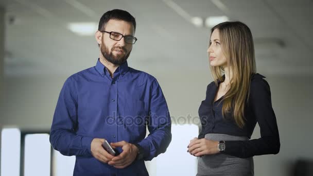 En el edificio de oficinas. Los trabajadores pasan tiempo libre hablando en un pasillo. El hombre discute asuntos de negocios con el jefe . — Vídeo de stock