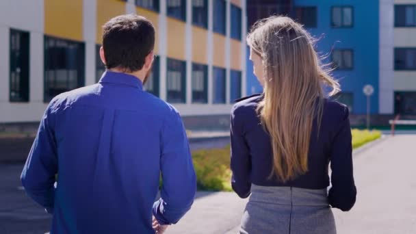 Edificio de oficinas. El director del centro de negocios y el secretario durante un descanso en la calle. El joven discute los asuntos adicionales con el joven trabajador . — Vídeo de stock