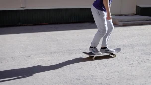 Nära upp skott av en manlig skateboardåkare, som utför en kick flip på en skateboard i gångkläder, människor njuta livsstilen — Stockvideo
