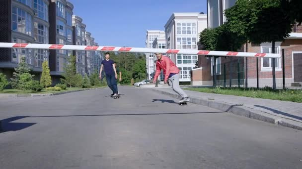 Diversi skateboarder adulti passano sotto la barriera sulla tavola, i ragazzi vanno allo skatepark per praticare i trucchi. — Video Stock