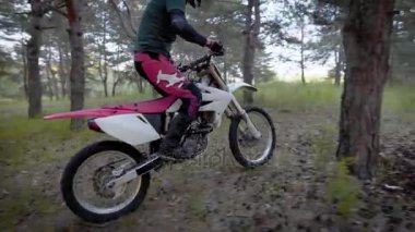 Koruyucu kask ve üniforma, Yetişkin motosikletçi düzgünce rides bir kırsal orman yoluyla yoluyla bir enduro motosiklet üzerinde bir spor adamı bir araç kullanır