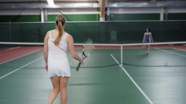 Yetişkin kadın tenis maçı bitmiş, beyaz spor giyim bir kadında yarışmasını, sportswomen sarılmak ve el sallamak