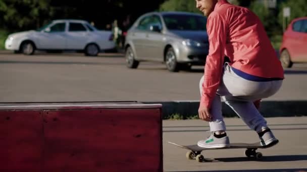 Uomo sconosciuto che salta con lo skateboard sul cavalletto in metallo nel parco — Video Stock