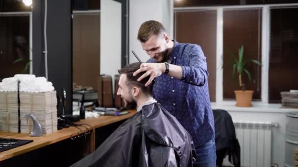 Посетитель парикмахерской хочет сделать модную прическу в парикмахерской, взрослый мужчина ожидает, что линия волос будет подстрижена — стоковое видео