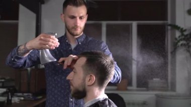 Kuaför atomizer sona erdirmek saç kesimi için bekleyen berber ziyaretçiye kafasına su sıçramalarına
