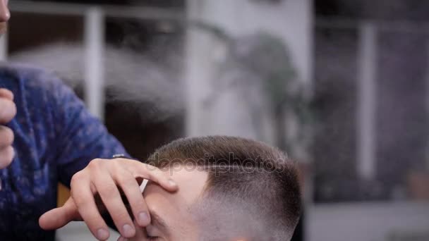 Un visitatore del negozio di barbiere è venuto al salone per cambiare la sua immagine, il parrucchiere utilizza lacca per capelli per creare una nuova acconciatura e stile. — Video Stock