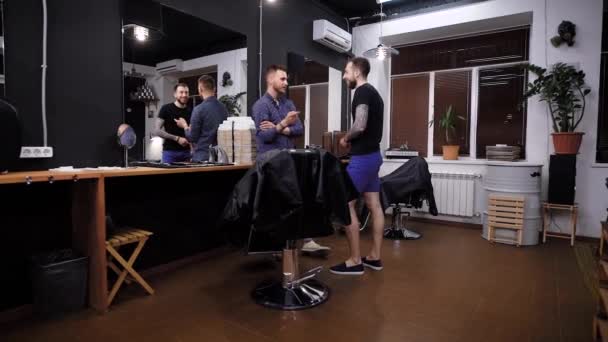 Zdarma a aktivní kadeřník rozhovory klientovi holičství, muž chce zjistit, jaký účes klienta salonu čeká na — Stock video
