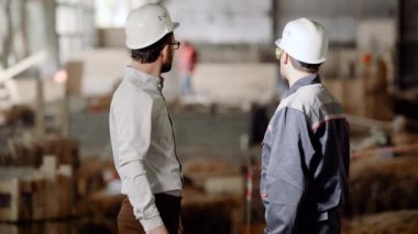 Sitede anonim işçiler. Arkadan görünüşü danışman ve inşaat uzak site seyir işbirliği işçisi.